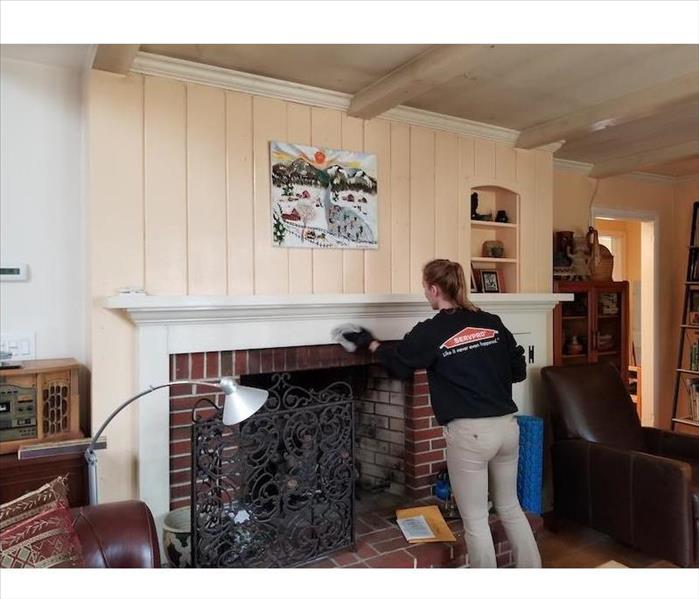 SERVPRO tech cleaning fireplace mantle